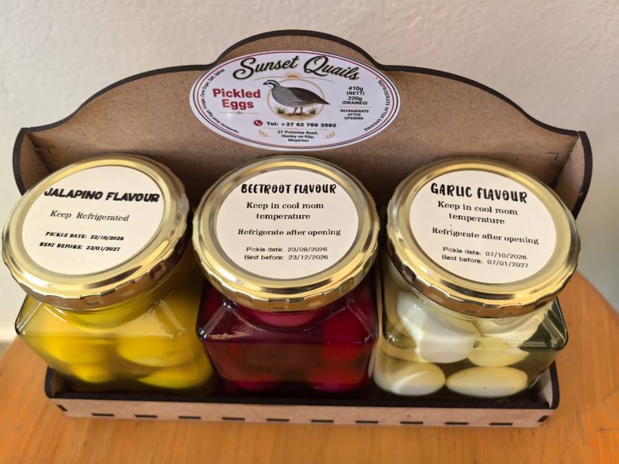 Three jars in the wooden gift box showing their flavour lids